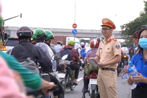 CSGT TP.HCM phát nón bảo hiểm, nước uống cho người dân về quê