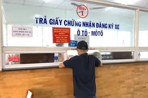 Người dân nhận giấy chứng nhận đăng ký xe. Ảnh: PHƯỢNG HUỲNH