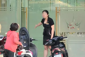 Chiều 2-10, nhân viên của Viện thẩm mỹ Medic Skin Đà Nẵng mở cửa mời chào khách hàng vào bên trong dù bị đình chỉ hoạt động. Ảnh: MINH TRƯỜNG 