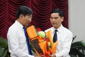 Ông Dương Văn An, Bí thư Tỉnh ủy Bình Thuận, tặng hoa tân Chủ tịch UBND tỉnh Lê Tuấn Phong. Ảnh: PN
