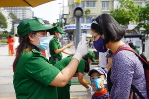 Người dân và du khách tham quan đường hoa Nguyễn Huệ (TP.HCM) được đo thân nhiệt kĩ càng. Ảnh: NGUYỄN TRÀ