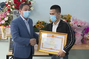 Phó Chủ tịch TP Hà Nội Lê Hồng Sơn đến thăm, trao bằng khen đột xuất của Thủ tướng cho anh Nguyễn Ngọc Mạnh. Ảnh: TTXVN