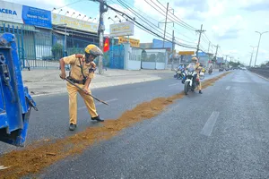 Người dân trượt té vì vệt nhớt, CSGT Tân Túc dang nắng rải cát xuống đường