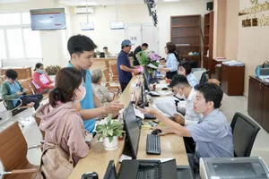 Cán bộ Trung tâm phục vụ hành chính công phường Bình Đông hướng dẫn người dân làm thủ tục hành chính.