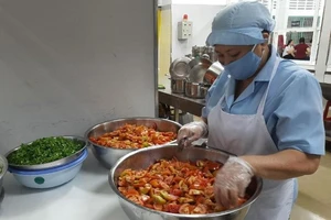 Nhân viên nhà bếp Trường Tiểu học Trưng Trắc (quận 11, TP.HCM) đang sơ chế thực phẩm. Ảnh: TRẦN NGỌC 