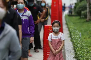 Em nhỏ xếp hàng cùng mẹ tại điểm lấy mẫu xét nghiệm ở phường Hòa Thạnh, quận Tân Phú, TP.HCM. Ảnh: Trường Giang.