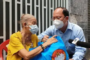 Phó Bí thư Thành ủy Nguyễn Hồ Hải thăm hỏi, động viên và tặng quà người dân gặp khó khăn ở quận Tân Bình, hôm 3-8. Ảnh: NT