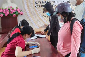 Người dân ở phường 5, quận Gò Vấp nhận hỗ trợ đợt 3. Ảnh: NGUYỄN HIỀN