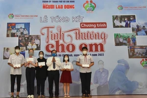 Ông Tô Đình Tuân, Tổng Biên tập Báo Người Lao Động, trao quà cho các em mồ côi vì Covid-19. (Ảnh do Báo Người Lao Động cung cấp)
