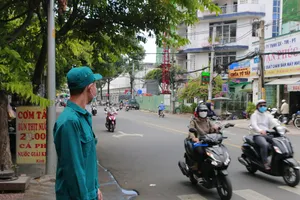 Một dân quân tự vệ đang làm nhiệm vụ điều tiết giao thông. Ảnh: Minh Thuận