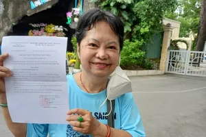 Bà Hà vui mừng khi được cấp giấy xác nhận độc thân. ảnh: NGUYỄN HIỀN