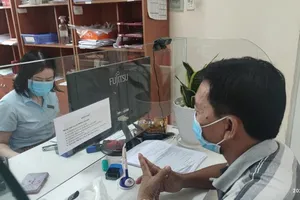 Người dân đến cơ quan BHXH quận 12 thực hiện thủ tục hành chính liên quan đến BHXH. Ảnh: NGUYỄN HIỀN