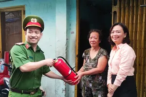 Công an phường tặng bình PCCC cho hộ dân trên địa bàn phường Bến Thành, quận 1. Ảnh: NGUYỄN HIỀN