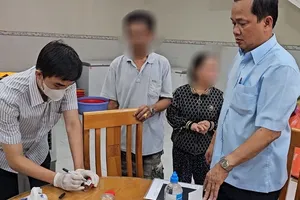 Sau khi nhiều người nhập viện nghi do ngộ độc, đoàn công tác của Bộ Y tế đến lấy mẫu xét nghiệm tiệm bánh mì của bà B. Ảnh: VH