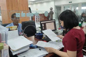 Cán bộ cơ quan BHXH TP.HCM đang tiếp người dân đến thực hiện một số thủ tục liên quan đến BHXH. Ảnh: NGUYỄN HIỀN