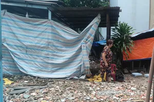 Bà Huệ bên căn nhà đã bị tháo dỡ vì xuống cấp không thể ở được và đang chờ xin cấp giấy phép xây dựng. Ảnh: NGUYỄN HIỀN