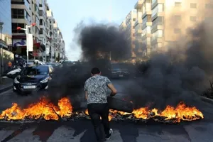 Một người đàn ông đốt lốp xe trong cuộc biểu tình ở thủ đô Beirut nhằm phản đối điều kiện sống tồi tệ ở nước này vào ngày 28-6.
