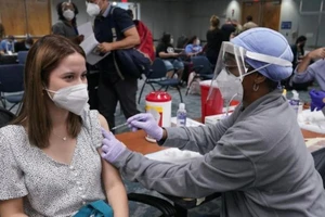 Người dân Mỹ được nhân viên y tế tiêm vaccine ngừa COVID-19.