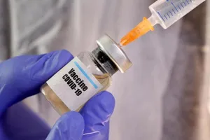 Nhân viên y tế đang lấy vaccine ngừa COVID-19 từ lọ chứa.