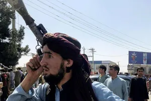 Một thành viên của lực lượng Taliban kiểm tra khu vực bên ngoài Sân bay Quốc tế Hamid Karzai ở Kabul, Afghanistan hôm 16-8.