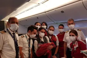 Phi hành đoàn chụp hình cùng đứa trẻ mới sinh.