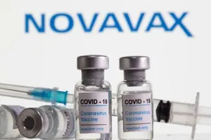 Các lọ vaccine ngừa COVID-19 xếp phía trước logo tập đoàn công nghệ sinh học Mỹ Novavax.