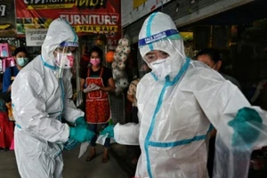 Nhân viên y tế lấy mẫu tăm bông cho vào ống nghiệm thủy tinh và tiến hành khử trùng.