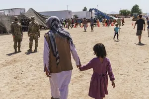 Một người đàn ông đi bộ với một đứa trẻ tại căn cứ quân sự Fort Bliss, nơi những người tị nạn Afghanistan đang tạm trú, ngày 10-9.