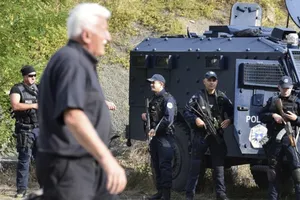 Các sĩ quan cảnh sát đặc nhiệm Kosovo đứng gác khi hàng trăm người Serbia ở Kosovo phản đối lệnh cấm đối với các phương tiện mang biển đăng ký Serbia, ngày 27-9.