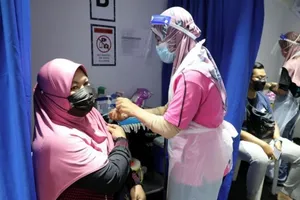Người dân Malaysia được tiêm vaccine ngừa COVID-19 tại một trạm y tế.