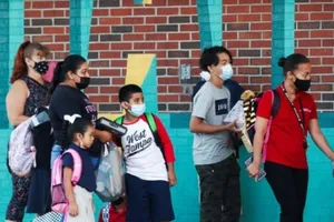 Phụ huynh dắt con đi học trong ngày đầu tiên tụ trường tại trường tiểu học West Tampa ở Florida, Mỹ, ngày 10-8.