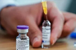 Nhân viên y tế đang lấy vaccine Pfizer/BioNTech từ lọ bằng kim tiêm.