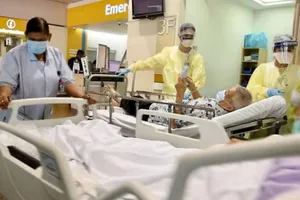 Các nhân viên y tế đang di chuyển những bệnh nhân lớn tuổi nhiễm COVID-19 đến phòng chăm sóc đặc biệt tại khoa cấp cứu tại bệnh viện Tan Tock Seng, Singapore.