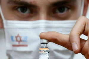 Một y tá Israel cầm lọ vaccine ngừa COVID-19 Pfizer/BioNtech cho trẻ em.