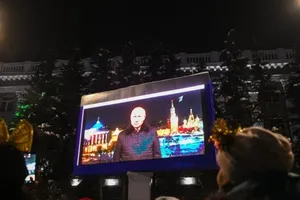Người dân Nga đứng xem đoạn video Tổng thống Vladimir Putin đưa ra thông điệp năm mới ở Kemerovo vào ngày 31-12-2021.