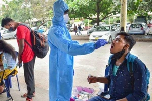 Nhân viên y tế lấy mẫu xét nghiệm COVID-19 cho người dân.