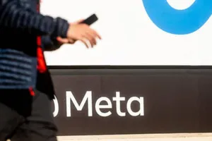 Một người đàn ông đi ngang qua tấm bảng hiệu của tập đoàn công nghệ khổng lồ Meta của Mỹ.
