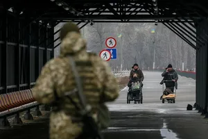 Người dân đi qua ranh giới giữa khu vực ly khai và đất thuộc chủ quyền Ukraine tại khu định cư Stanytsia Luhanska, ngày 23-2.