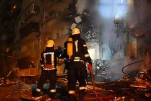 Lực lượng cứu hỏa tìm cách dập tắt ngọn lửa bùng lên sau khi mảnh vỡ quả tên lửa rơi trúng tòa nhà dân cư 9 tầng.