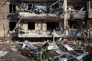 Một binh sĩ Ukraine kiểm tra đống đổ nát của một chung cư bị phá hủy ở Kiev vào ngày 15-3 sau khi Nga tấn công vào khu dân cư khiến ít nhất 2 người thiệt mạng.
