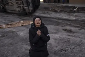 Một cụ bà quỳ khóc khi người thân của bà đã bị giết chết ở Bucha, Ukraine.