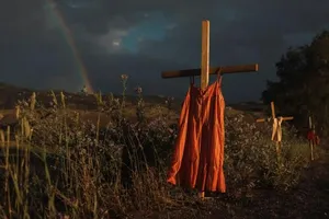 Những chiếc váy đỏ treo trên thánh giá dọc theo một con đường để tưởng nhớ những trẻ em đã chết trong quá khứ tại trường nội trú người da đỏ Kamloops hồi thế kỷ 19 sau khi 215 ngôi mộ không được đánh dấu được phát hiện vào năm 2021.