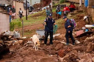 Lực lượng cứu hộ sử dụng chó nghiệp vụ để tìm kiếm thi thể các nạn nhân bị vùi lấp trong đống đất đá sau trận lũ lụt ở Nam Phi, ngày 17-4.