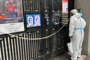 Một nhân viên chuyển phát nhanh trong bộ đồ bảo hộ chuyển hàng tại một khu dân cư bị phong tỏa ở TP Thượng Hải, ngày 30-4.