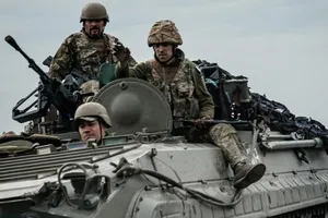 Binh sĩ Ukraine ngồi trên một chiếc xe bọc thép.