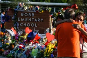 Người dân đặt hoa trước một đài tưởng niệm tạm thời tại trường tiểu học Robb ở TP Uvalde, bang Texas, nơi xảy ra vụ xả súng khiến 19 trẻ em và hai giáo viên thiệt mạng.