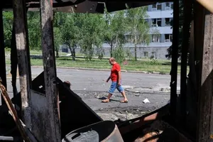 Một người đàn ông đi ngang qua một ngôi nhà bị phá hủy tại khu chợ địa phương sau các cuộc giao tranh giữa Ukraine và Nga ở Donetsk, ngày 19-6.