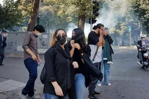 Người biểu tình ở thủ đô Tehran (Iran) bỏ chạy khi lực lượng an ninh bắt đầu ném hơi cay trong cuộc biểu tình hôm 2-10.