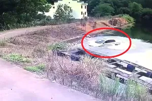 Lùi ô tô lùi luôn xuống ao