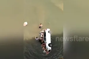 Hồi hộp giải cứu cả gia đình mắc kẹt khi xe lao xuống sông